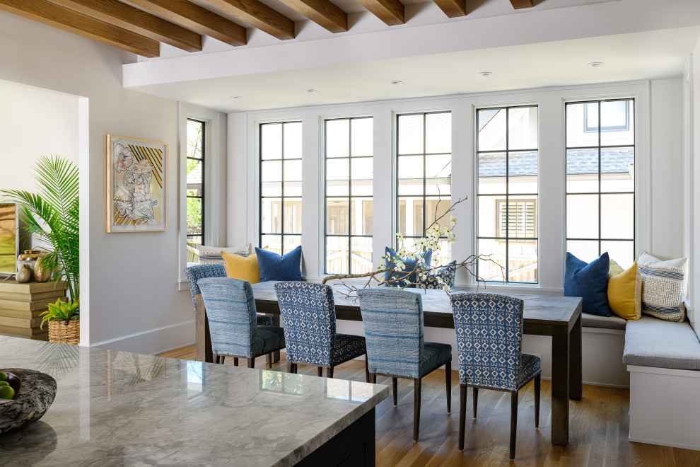 Cette photo montre une salle à manger ouverte sur la cuisine tendance avec un mur blanc, parquet clair et aucune cheminée.