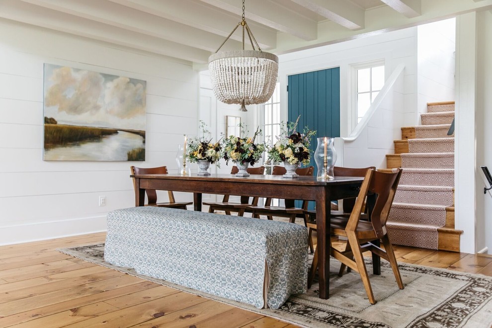 Foto di una grande sala da pranzo aperta verso il soggiorno country con pareti bianche, parquet chiaro e pavimento marrone