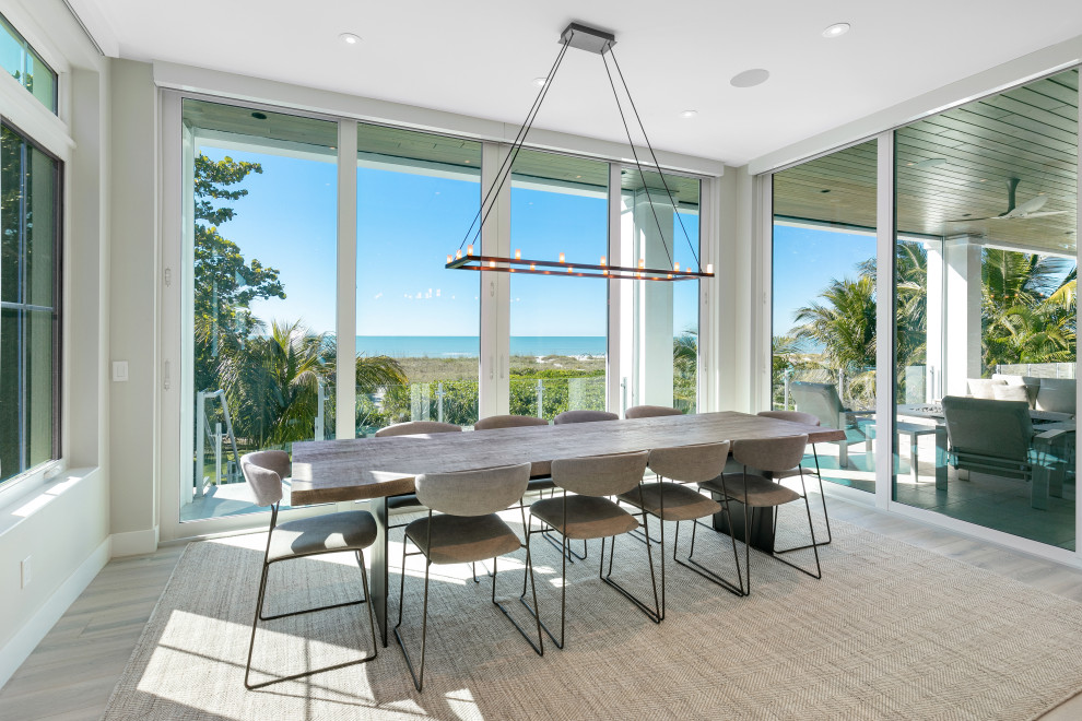 Photo of a large beach style dining room in Tampa with grey walls and grey floors.