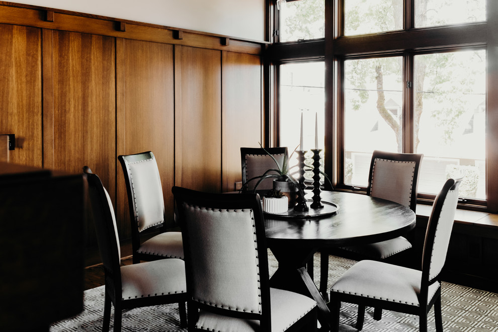 Immagine di una sala da pranzo american style chiusa e di medie dimensioni con pareti bianche, pavimento in legno massello medio, camino classico, cornice del camino piastrellata e pavimento marrone