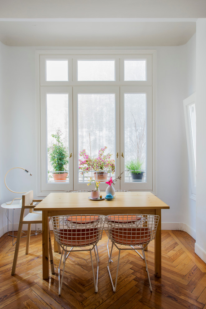 Idée de décoration pour une salle à manger minimaliste fermée et de taille moyenne avec un mur blanc, un sol en bois brun et aucune cheminée.