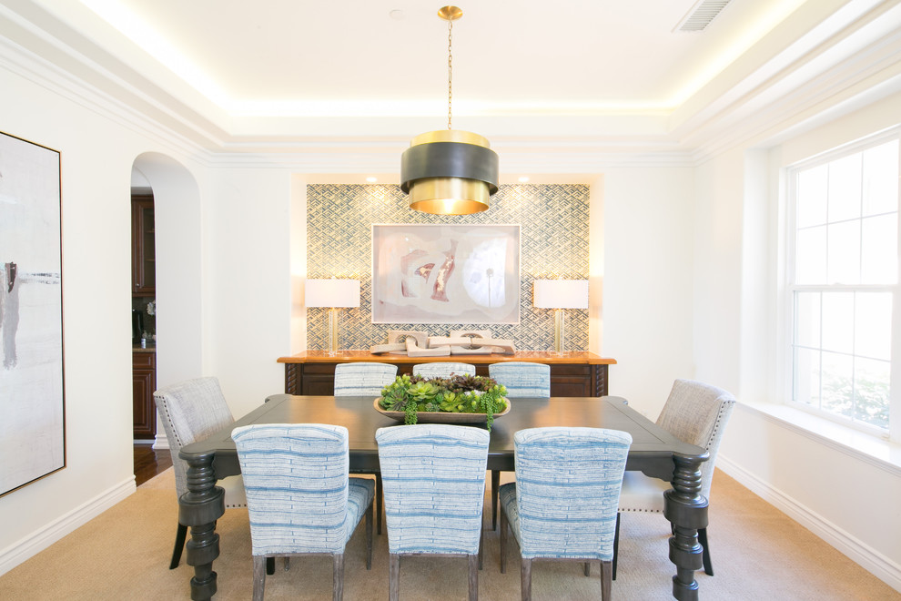 Photo of a coastal enclosed dining room in Orange County with white walls, carpet, no fireplace, beige floors and feature lighting.