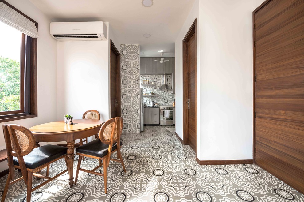 World-inspired dining room in Delhi with white walls and grey floors.