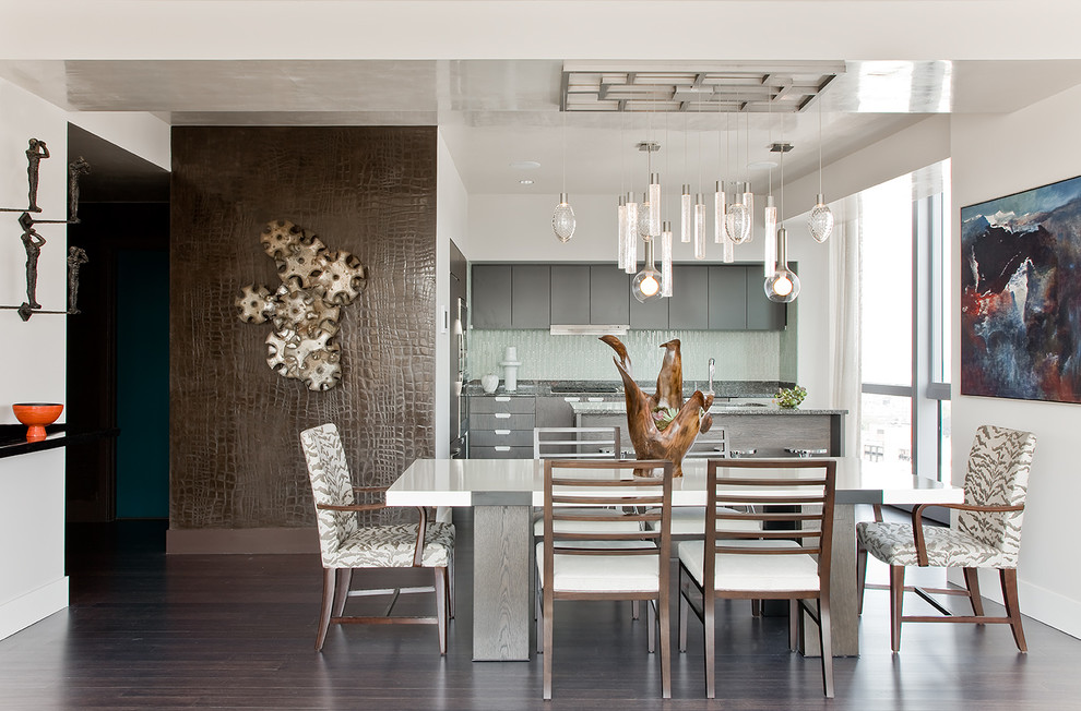 Foto di una sala da pranzo aperta verso la cucina minimal con pareti bianche e parquet scuro