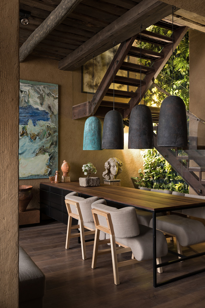 Cette photo montre une salle à manger ouverte sur le salon asiatique avec un mur marron, parquet foncé, aucune cheminée et un sol marron.