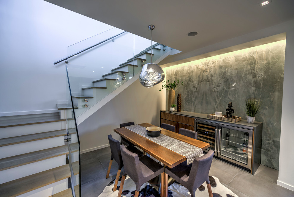 Cette image montre une salle à manger ouverte sur la cuisine minimaliste de taille moyenne avec un mur vert, un sol en ardoise et un sol gris.