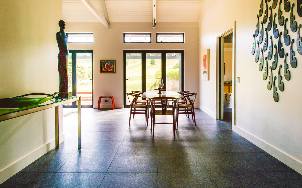 Foto di una sala da pranzo aperta verso la cucina design di medie dimensioni con nessun camino, pareti bianche, pavimento con piastrelle in ceramica e pavimento nero