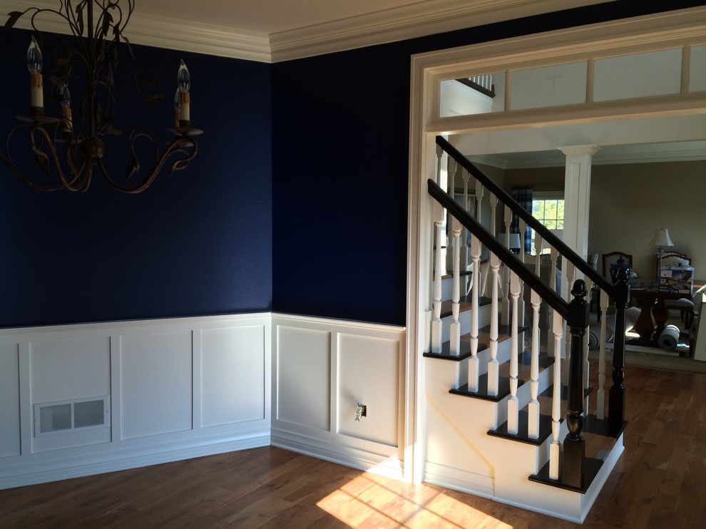 Esempio di una sala da pranzo aperta verso la cucina tradizionale di medie dimensioni con pareti blu e pavimento in legno massello medio