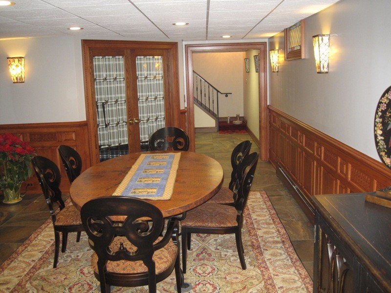 Large classic enclosed dining room in Other with white walls and slate flooring.