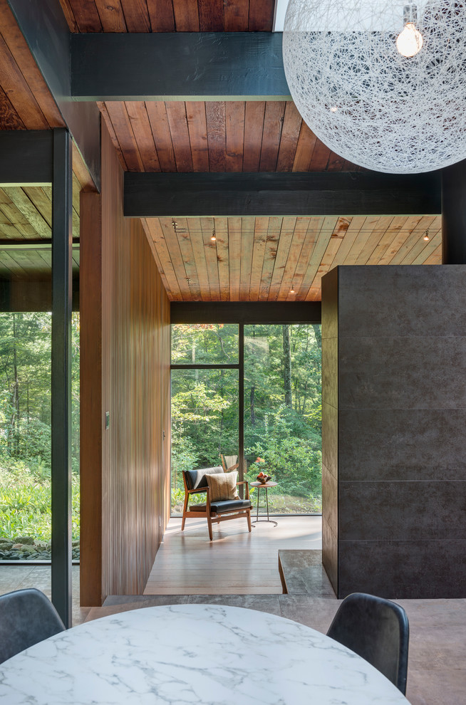 Mid-sized mid-century modern porcelain tile and gray floor great room photo in Boston with brown walls, a standard fireplace and a tile fireplace