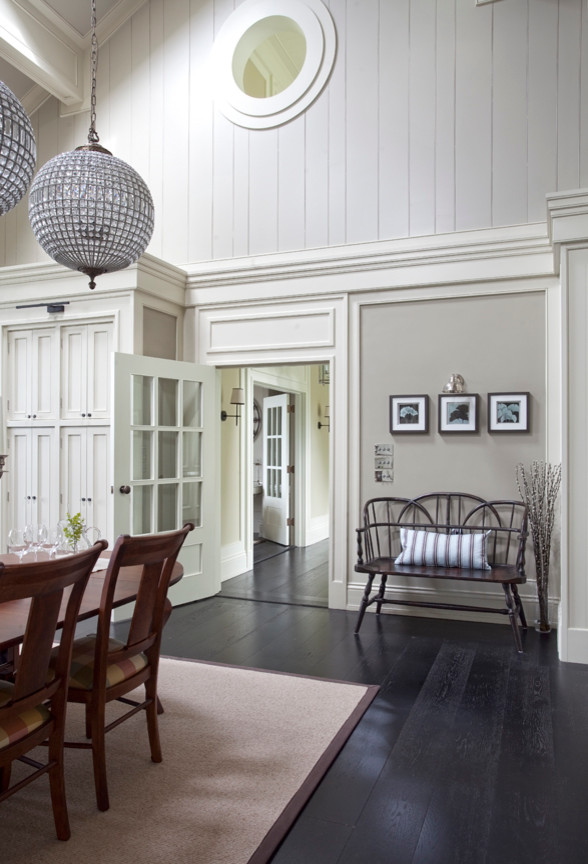 На фото: огромная гостиная-столовая в классическом стиле с темным паркетным полом и серыми стенами