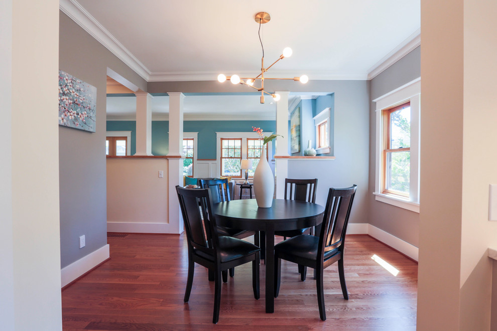Foto di una sala da pranzo aperta verso il soggiorno stile americano di medie dimensioni con pareti blu, pavimento in legno massello medio, nessun camino e pavimento marrone