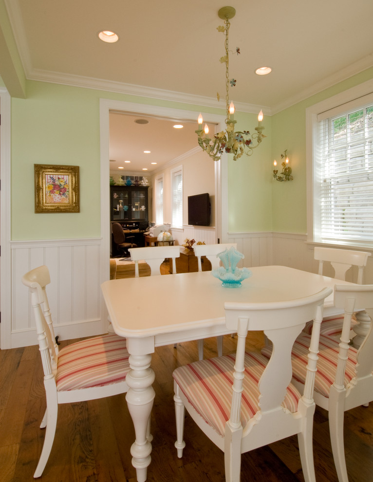 Example of a mid-sized beach style medium tone wood floor, brown floor and wainscoting kitchen/dining room combo design in Other with green walls