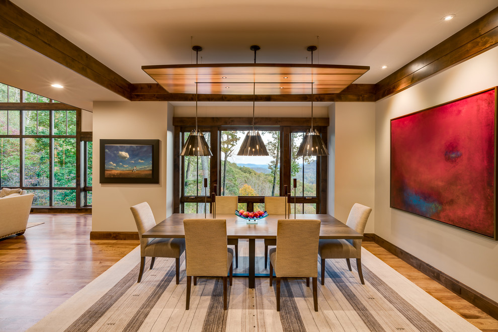 Immagine di una grande sala da pranzo aperta verso la cucina chic con pareti beige e pavimento in legno massello medio