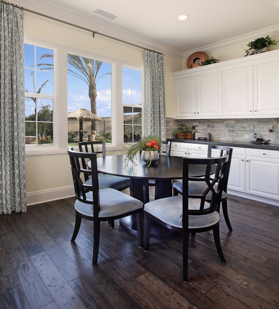 Example of an eclectic dark wood floor dining room design in Orange County with beige walls