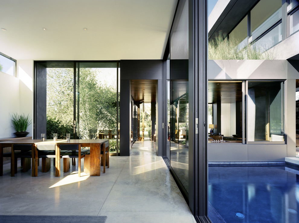 Photo of a contemporary dining room in London with concrete flooring.