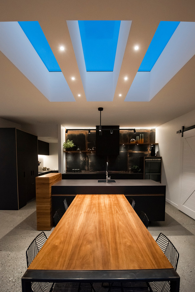 На фото: большая кухня-столовая в стиле модернизм с разноцветными стенами, бетонным полом и серым полом с