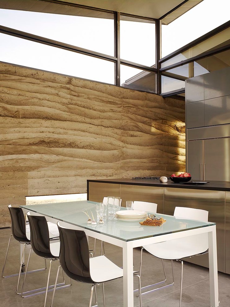 На фото: большая гостиная-столовая в современном стиле с коричневыми стенами и бетонным полом без камина