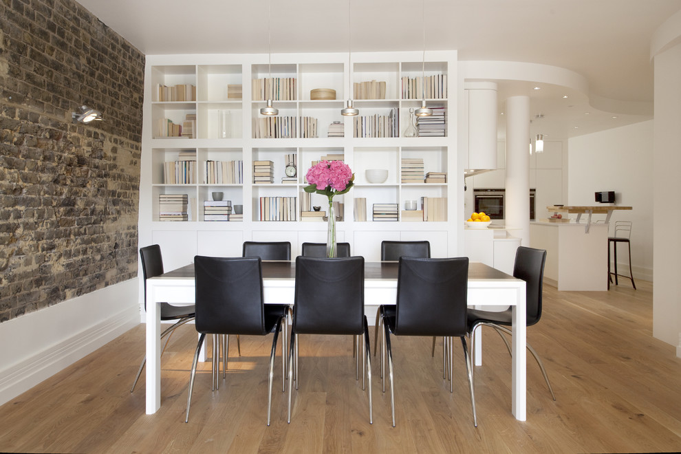 Dining room - contemporary medium tone wood floor dining room idea in London with white walls