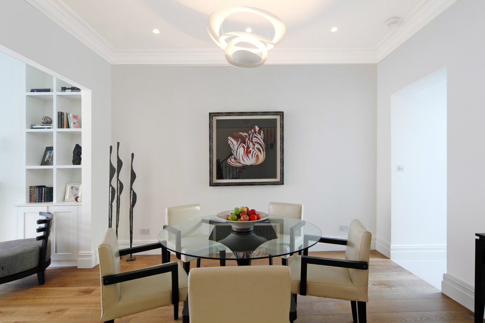 Medium sized contemporary enclosed dining room in London with white walls, medium hardwood flooring and no fireplace.