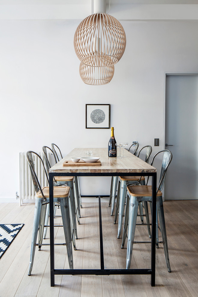 Bild på en mellanstor minimalistisk matplats med öppen planlösning, med ljust trägolv och vita väggar