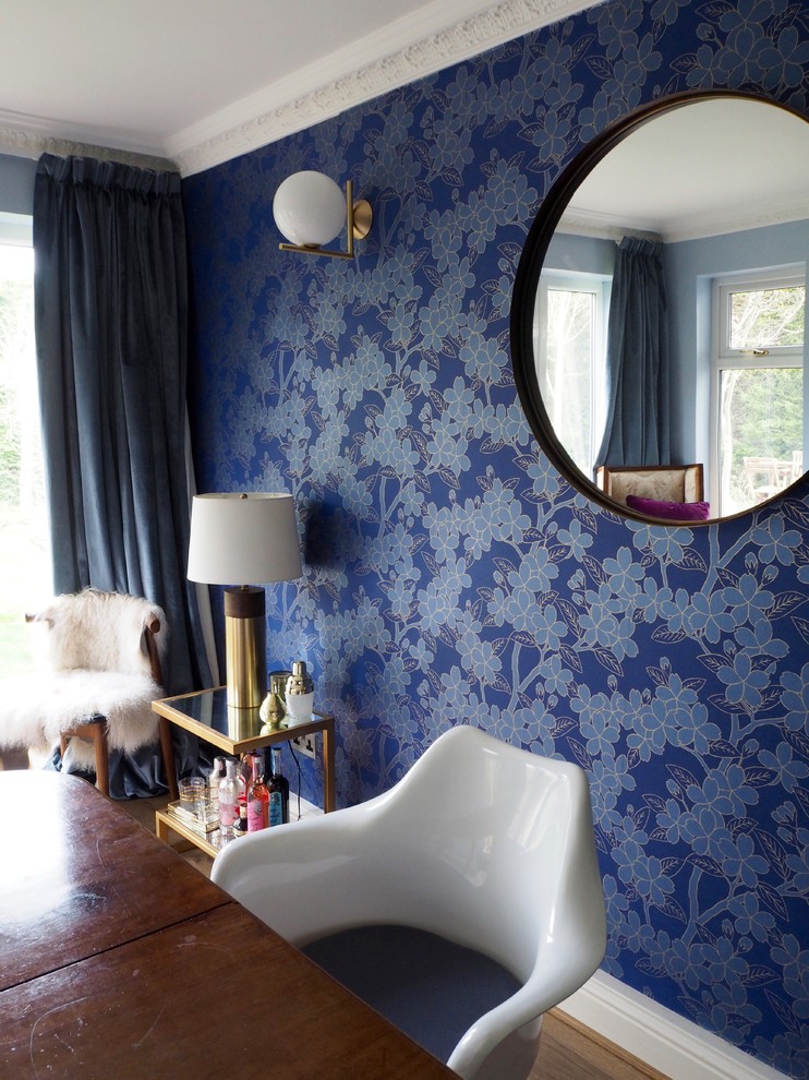 Diseño de comedor bohemio de tamaño medio cerrado con paredes azules, suelo laminado y suelo marrón