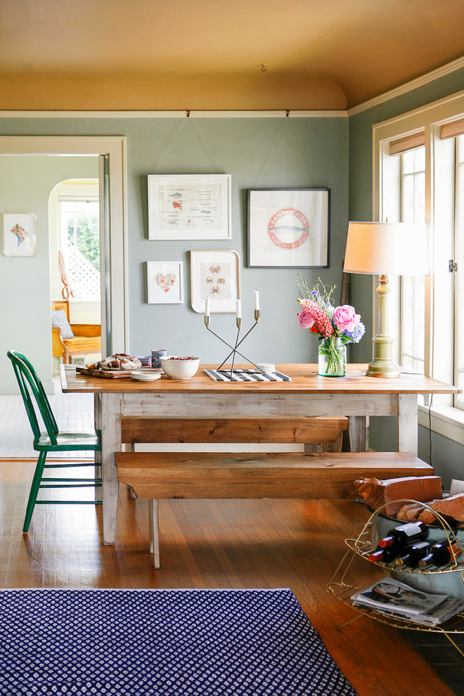Eclectic medium tone wood floor dining room photo in New York with green walls