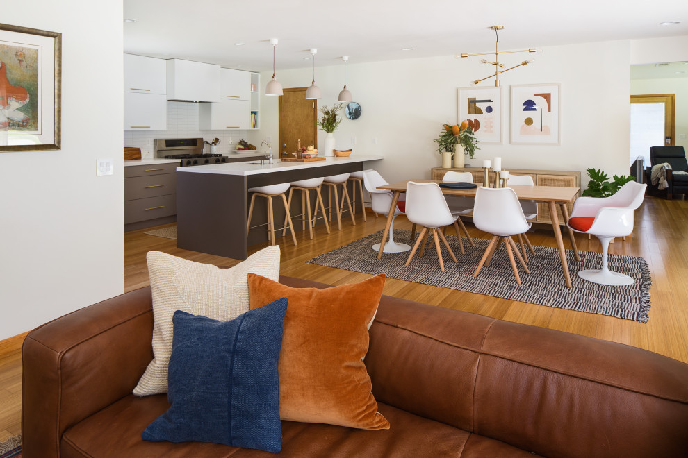 Inspiration for a mid-sized scandinavian bamboo floor and yellow floor kitchen/dining room combo remodel in Los Angeles with white walls, a standard fireplace and a tile fireplace