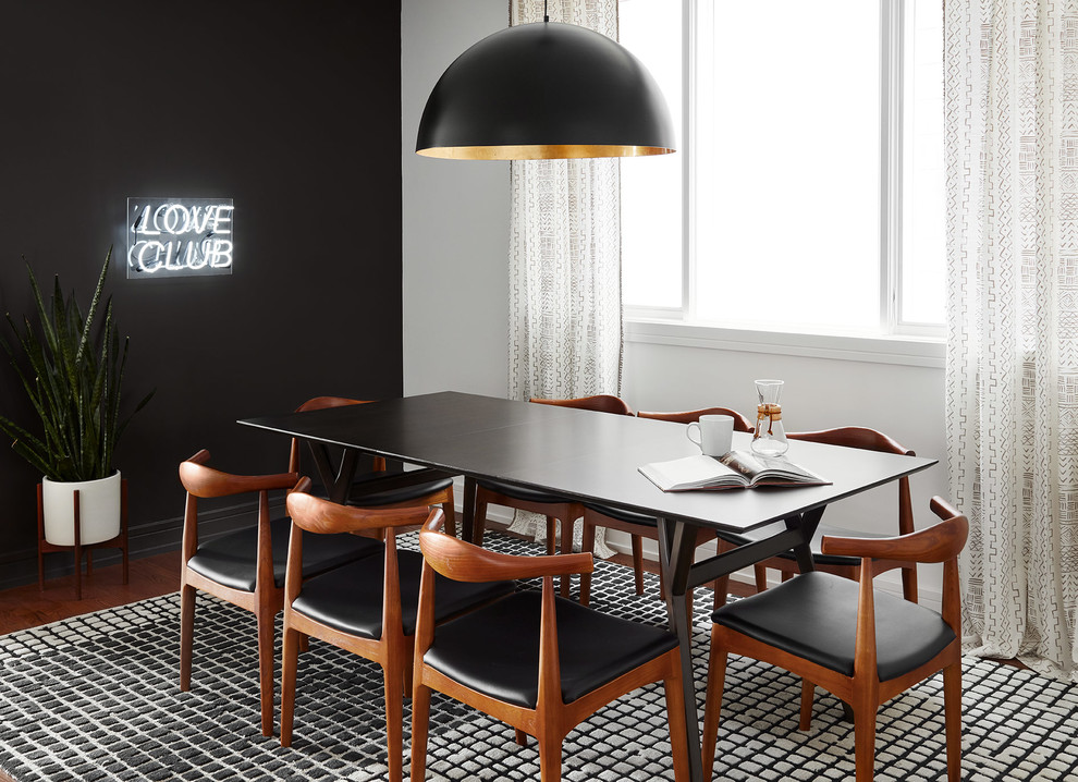 This is an example of a medium sized contemporary dining room in Chicago with black walls and dark hardwood flooring.