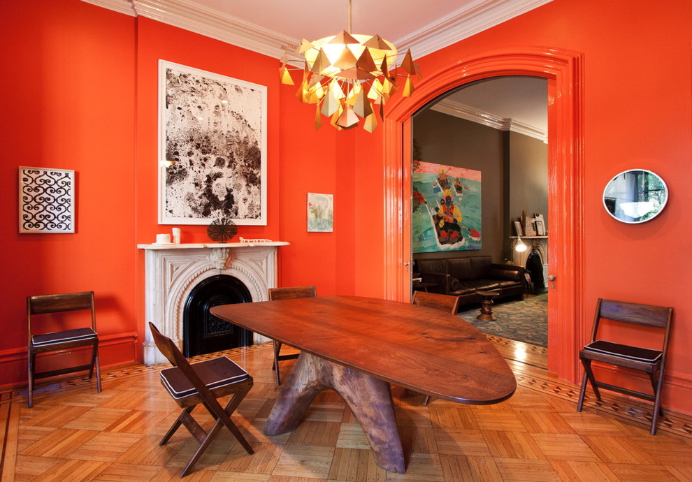 Cette image montre une salle à manger minimaliste avec un mur orange.