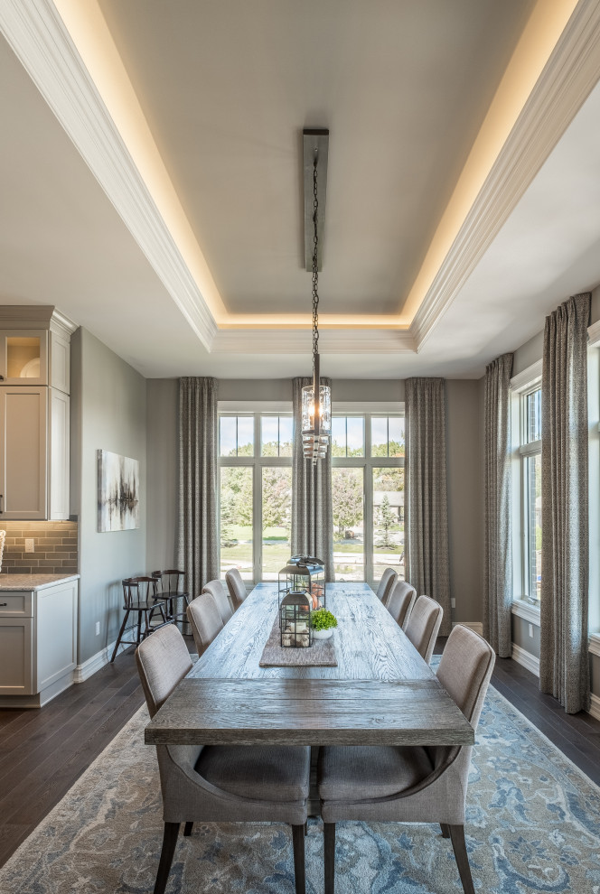 This is an example of a large country open plan dining room in Detroit with beige walls, dark hardwood flooring, brown floors and a drop ceiling.