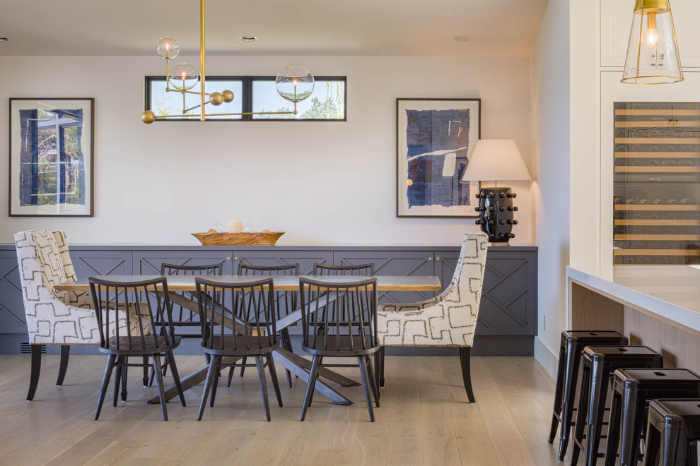 Idee per una sala da pranzo aperta verso il soggiorno stile marino con pareti bianche, parquet chiaro e nessun camino