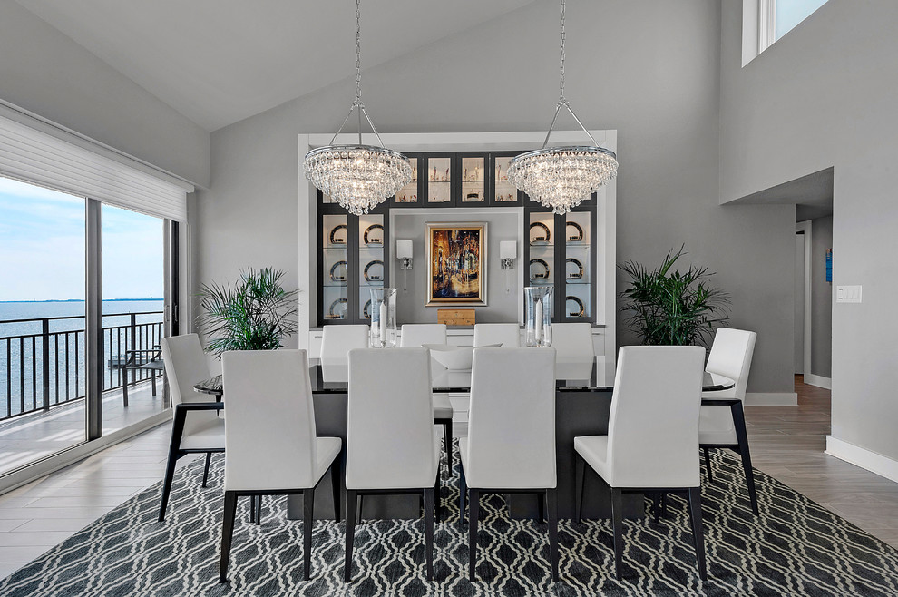 Idée de décoration pour une grande salle à manger ouverte sur la cuisine design avec un mur gris.