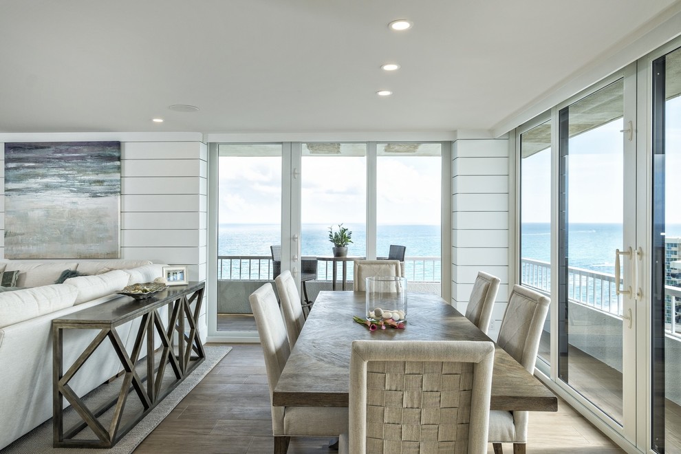 Exemple d'une salle à manger bord de mer de taille moyenne avec un mur blanc, un sol en carrelage de porcelaine et un sol beige.