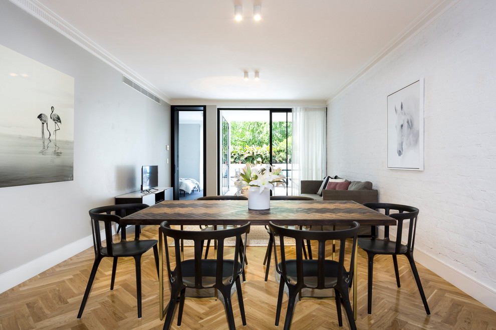 Foto di una sala da pranzo aperta verso il soggiorno contemporanea con pareti bianche, pavimento in legno massello medio e pavimento beige