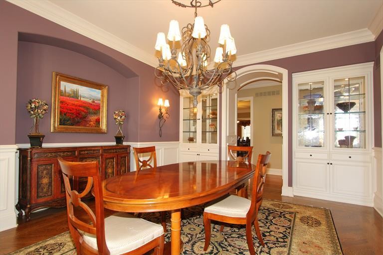 Imagen de comedor clásico renovado grande cerrado sin chimenea con paredes púrpuras y suelo de madera en tonos medios