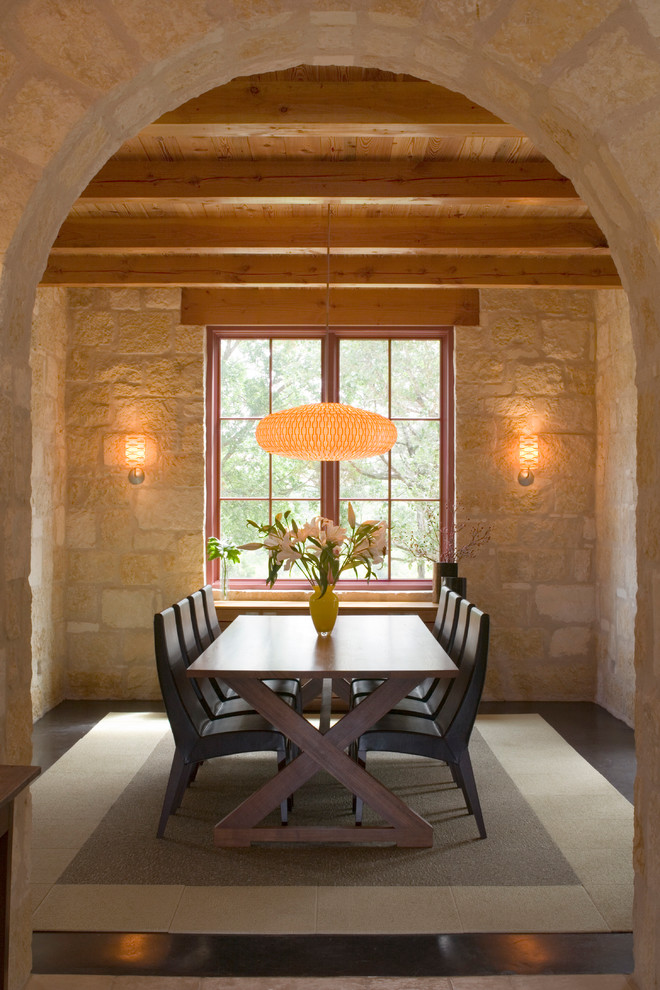 Immagine di una sala da pranzo mediterranea chiusa e di medie dimensioni con pareti beige e pavimento in cemento