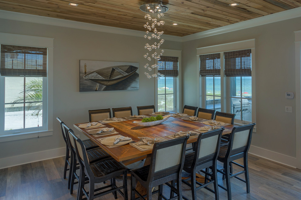Esempio di una grande sala da pranzo aperta verso il soggiorno costiera con pareti grigie, parquet chiaro e pavimento marrone