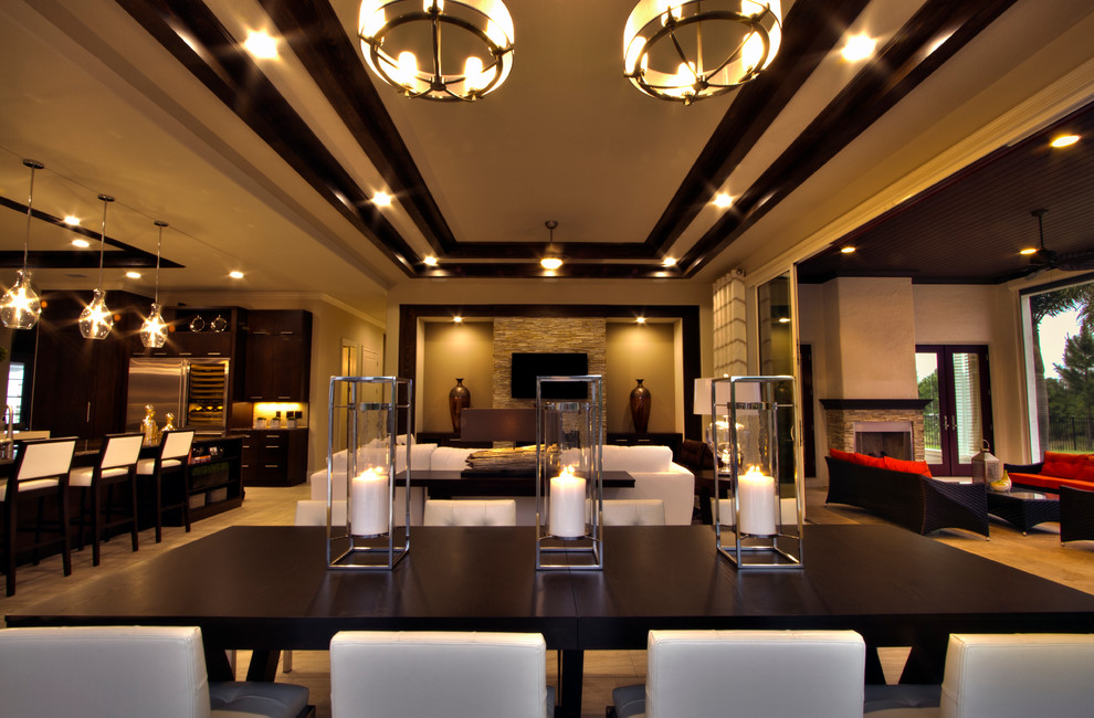 This is an example of a large contemporary open plan dining room in Orlando with beige walls, a standard fireplace, a stone fireplace surround, beige floors and marble flooring.