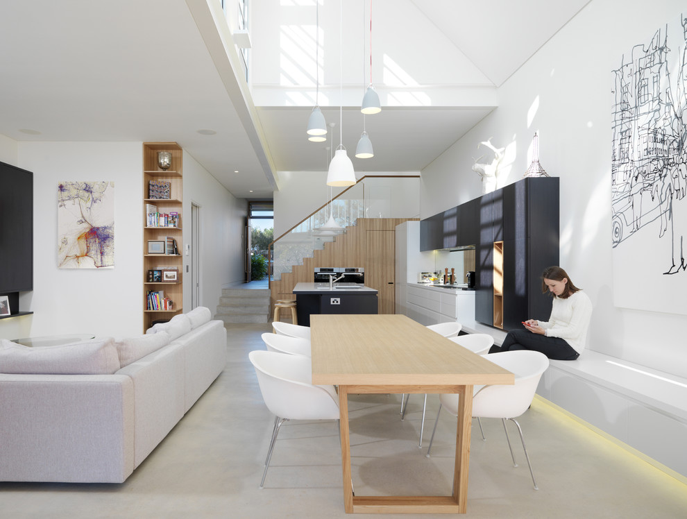 Photo of a large contemporary open plan dining room in Sydney with white walls, concrete flooring and white floors.