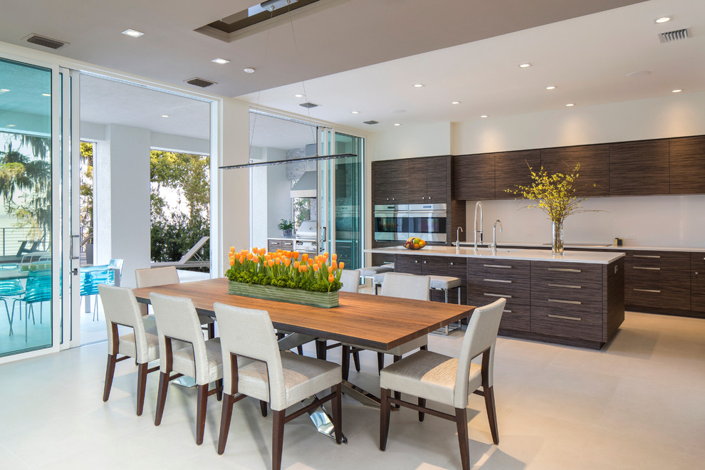 Foto di una grande sala da pranzo aperta verso la cucina contemporanea con pareti bianche e pavimento beige