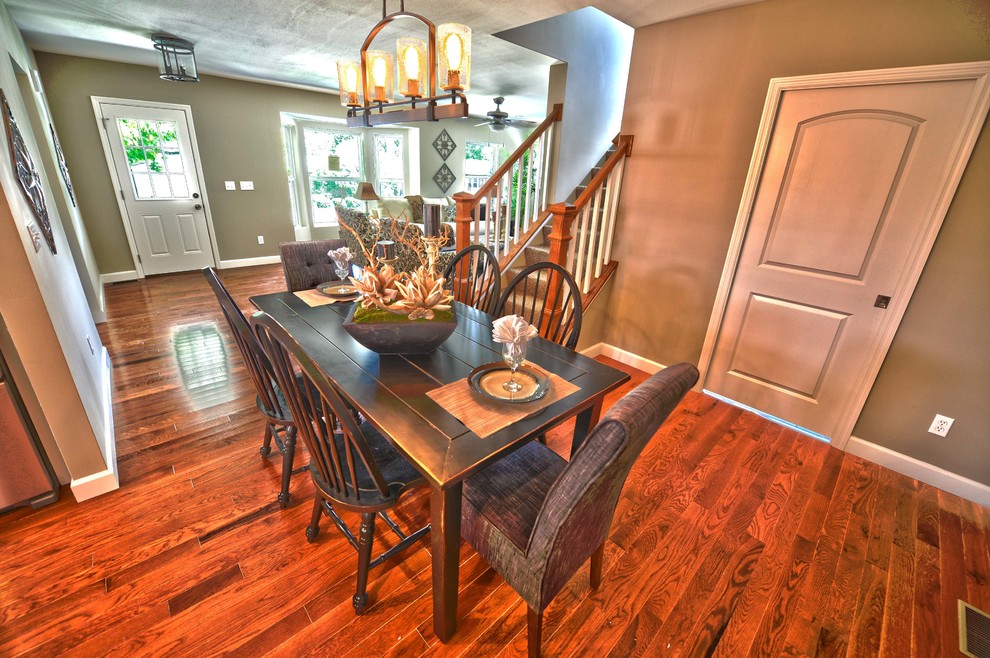 This is an example of a traditional open plan dining room in St Louis with beige walls and medium hardwood flooring.