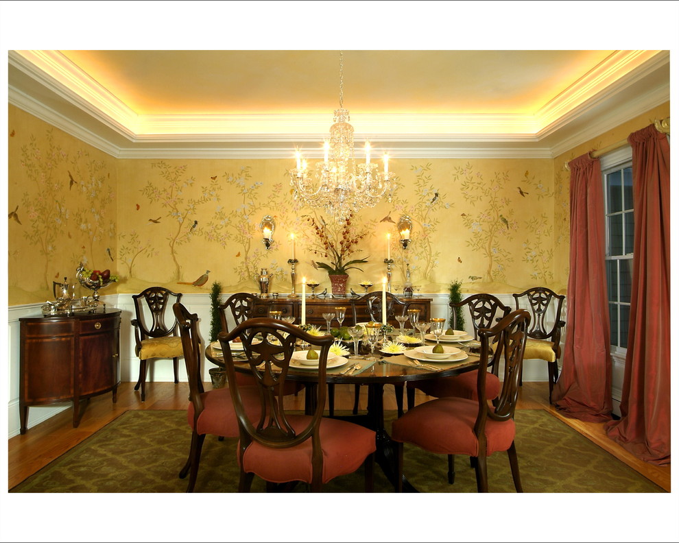 Diseño de comedor tradicional grande cerrado con paredes amarillas, suelo de madera en tonos medios y suelo marrón