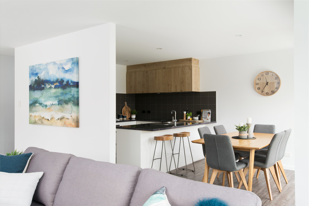Cette image montre une petite salle à manger ouverte sur le salon design avec un mur blanc, un sol en vinyl, aucune cheminée et un sol marron.