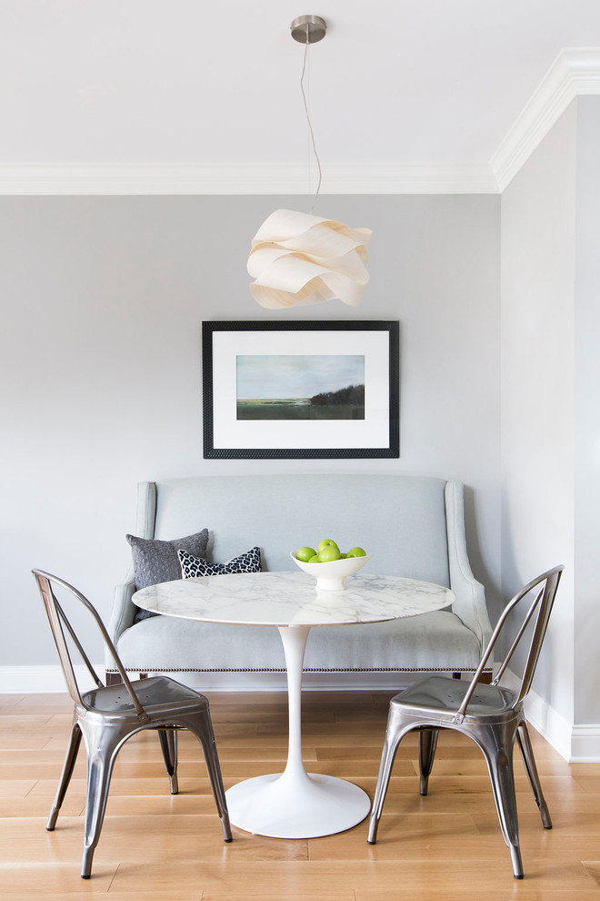 Example of a transitional light wood floor dining room design in Chicago with gray walls
