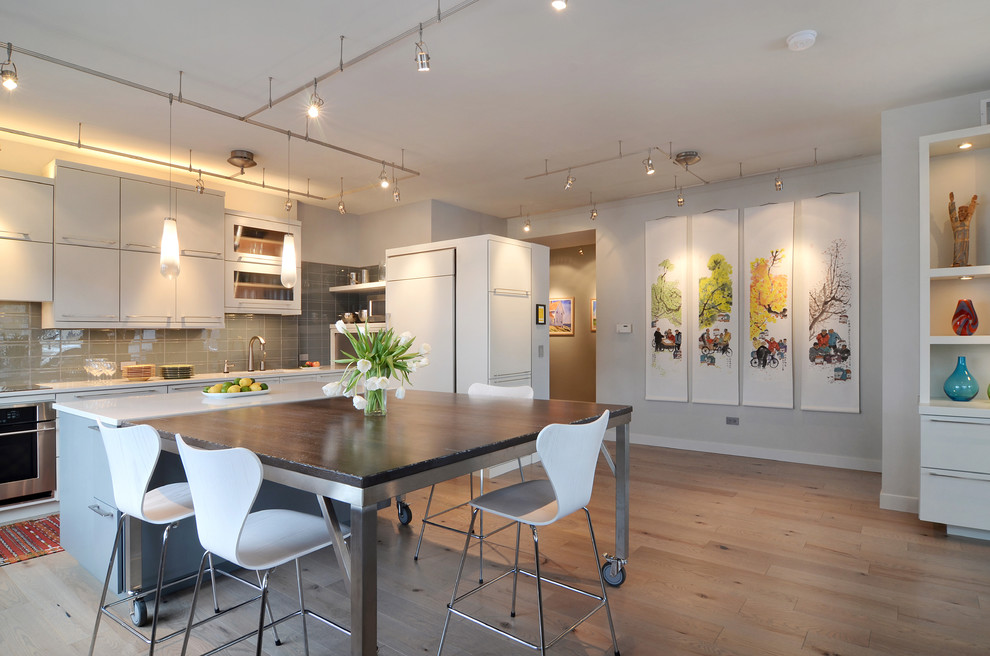 This is an example of a medium sized contemporary kitchen/dining room in Chicago with light hardwood flooring, grey walls, no fireplace and brown floors.