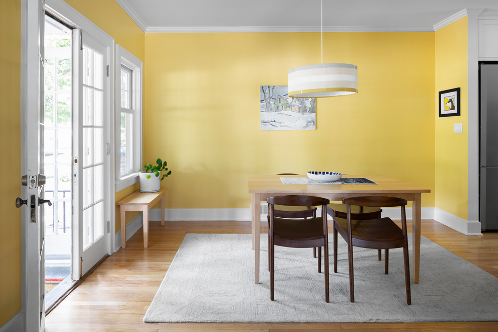 Modelo de comedor de cocina clásico renovado de tamaño medio con paredes amarillas, suelo de madera clara y suelo beige