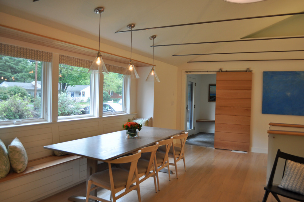 Ispirazione per una sala da pranzo aperta verso il soggiorno moderna di medie dimensioni con pareti bianche e parquet chiaro