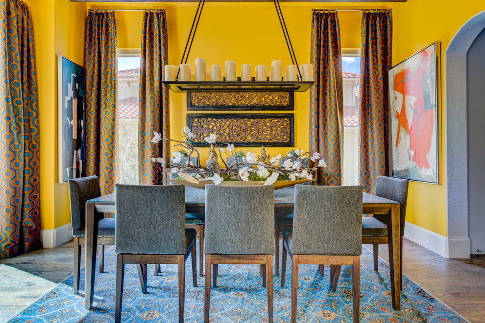 Réalisation d'une rideau de salle à manger tradition de taille moyenne et fermée avec un mur jaune, un sol en bois brun et aucune cheminée.