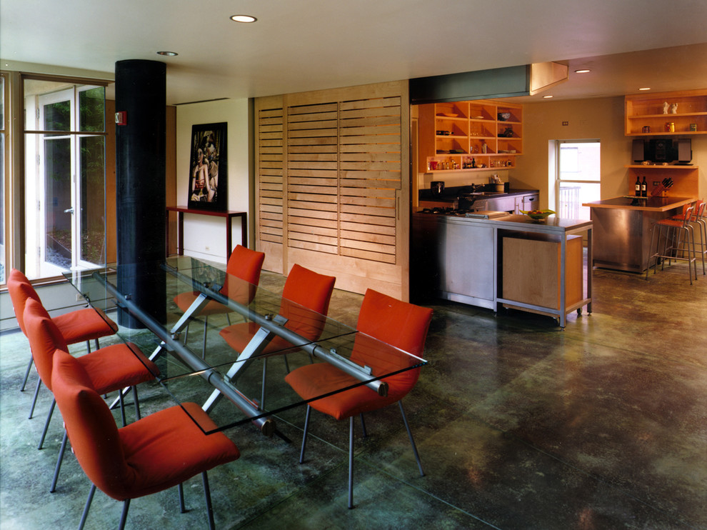 Esempio di una sala da pranzo minimal con pavimento in cemento